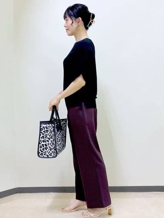 ブラック系のニット/セーター、ブラウン系のその他パンツ、ブラック系のトートバッグを着用したレディースの夏コーディネートの2枚目の写真