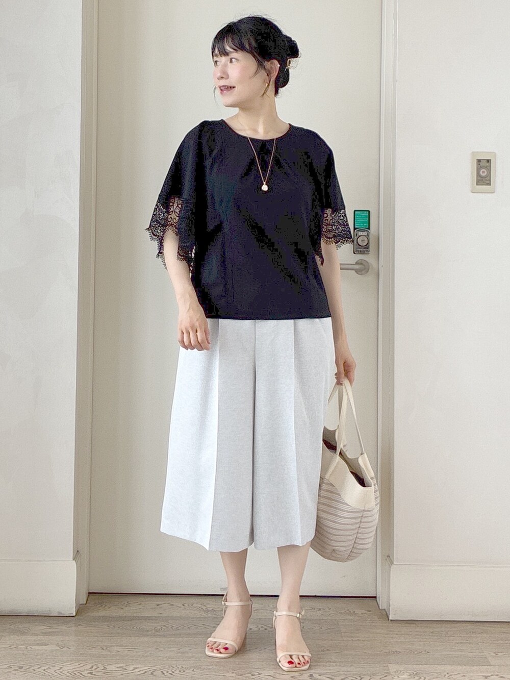 ブラック系のTシャツ/カットソー、グレー系のその他パンツ、ベージュ系のトートバッグを着用したレディースの夏コーディネートの7枚目の写真