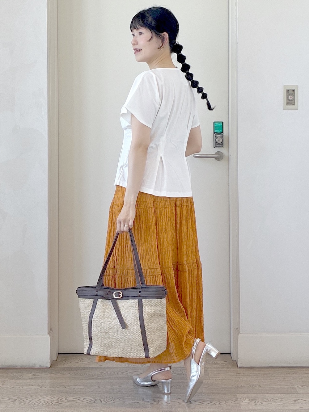 ホワイト系のTシャツ/カットソー、オレンジ系のスカート、イエロー系のトートバッグを着用したレディースの夏コーディネートの9枚目の写真