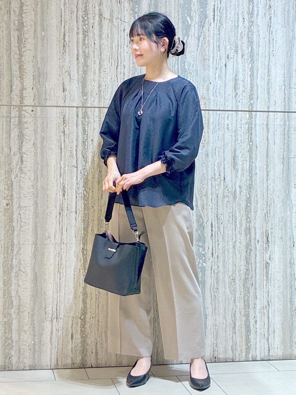 ブルー系のシャツ/ブラウス、ベージュ系のその他パンツ、ブラック系のブルゾンを着用したレディースの秋コーディネートの6枚目の写真