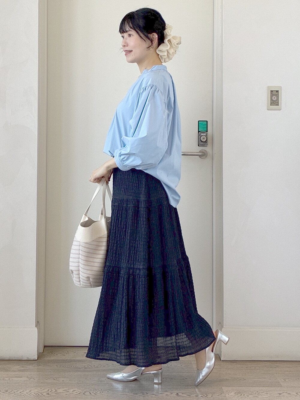ブルー系のシャツ/ブラウス、ベージュ系のトートバッグ、ベージュ系のタンクトップを着用したレディースの春コーディネートの2枚目の写真