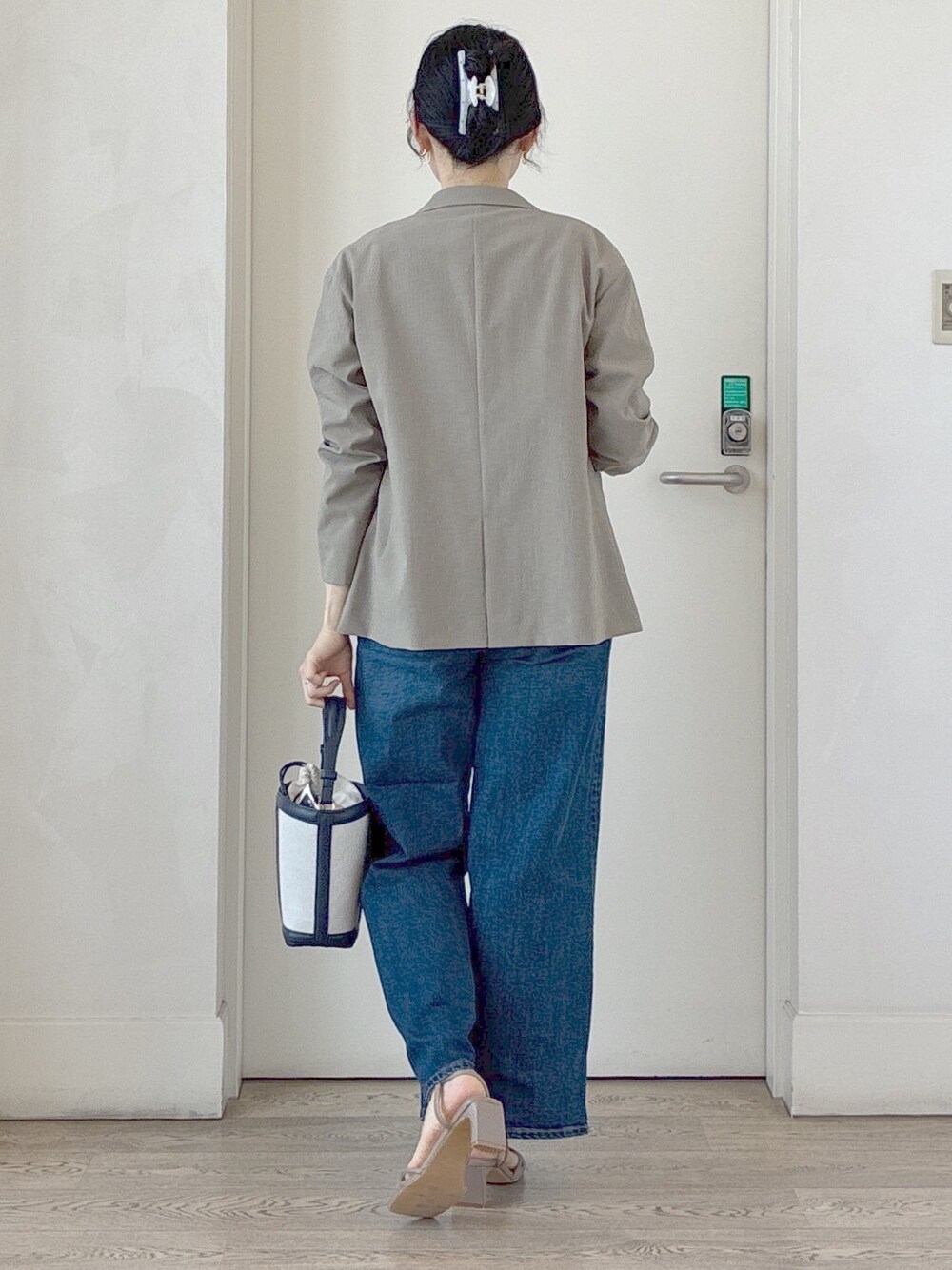 グリーン系のテーラードジャケット、ホワイト系のTシャツ/カットソー、ブルー系のデニムパンツを着用したレディースの夏コーディネートの3枚目の写真
