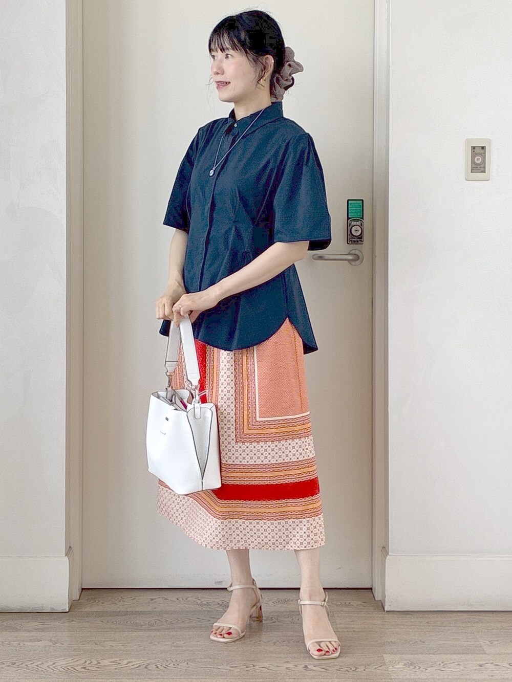 ブルー系のシャツ/ブラウス、オレンジ系のスカート、ホワイト系のトートバッグを着用したレディースの夏コーディネートの8枚目の写真