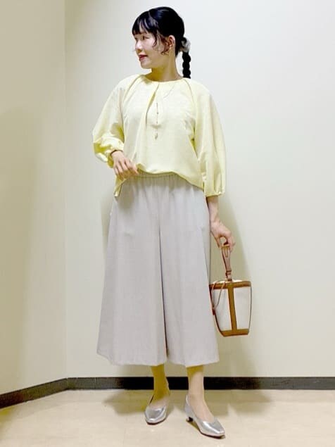 イエロー系のシャツ/ブラウス、シルバー系のパンプス、イエロー系のショルダーバッグを着用したレディースの春コーディネートの9枚目の写真