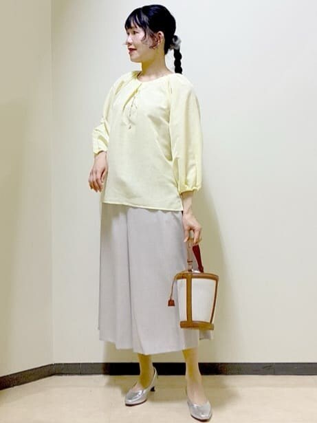 イエロー系のシャツ/ブラウス、シルバー系のパンプス、イエロー系のショルダーバッグを着用したレディースの春コーディネートの5枚目の写真