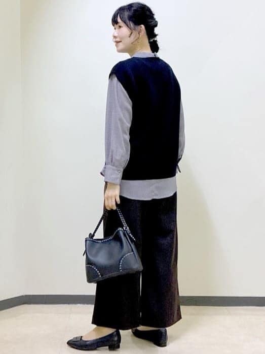 ブラック系のベスト、レッド系のシャツ/ブラウス、ブラウン系のその他パンツを着用したレディースの秋コーディネートの4枚目の写真