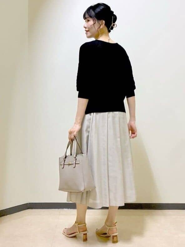 ブラック系のニット/セーター、ベージュ系のスカート、ブラウン系のスカートを着用したレディースの夏コーディネートの4枚目の写真