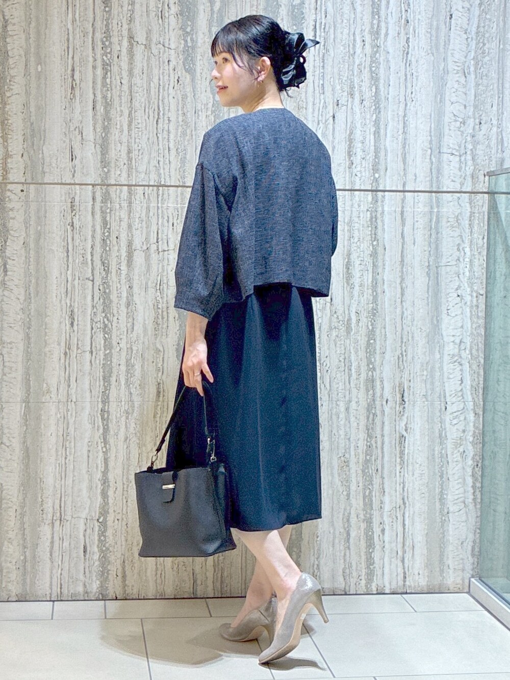 ブルー系のノーカラージャケット、ブルー系のワンピース、ブラック系のトートバッグを着用したレディースの夏コーディネートの4枚目の写真