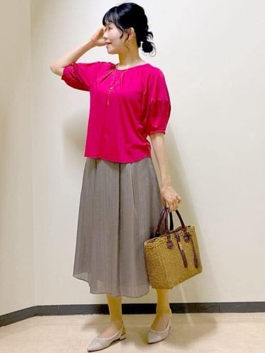 レッド系のTシャツ/カットソー、グリーン系のスカート、イエロー系のトートバッグを着用したレディースの夏コーディネートの6枚目の写真
