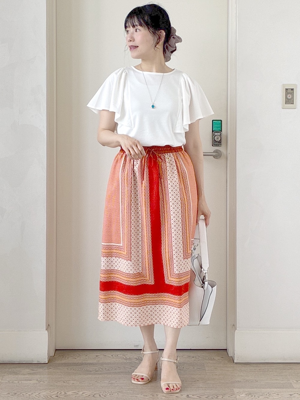 ホワイト系のTシャツ/カットソー、オレンジ系のスカート、ホワイト系のトートバッグを着用したレディースの夏コーディネートの5枚目の写真