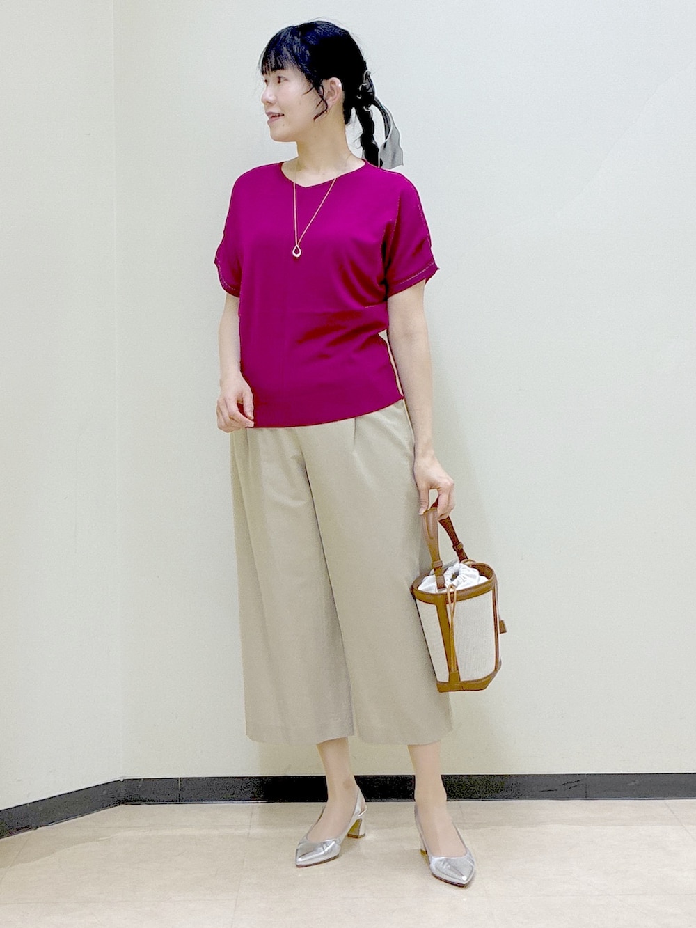 ピンク系のニット/セーター、ベージュ系のその他パンツ、イエロー系のショルダーバッグを着用したレディースの春コーディネートの8枚目の写真