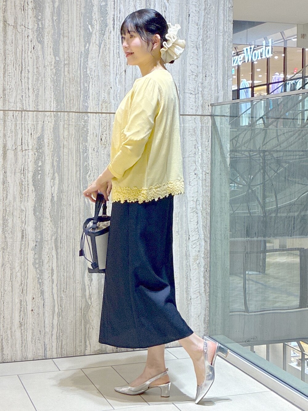 イエロー系のカーディガン/ボレロ、ホワイト系のTシャツ/カットソー、ブルー系のスカートを着用したレディースの夏コーディネートの2枚目の写真