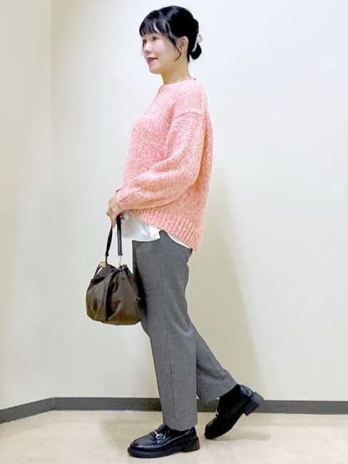ブラック系のチェスターコート、レッド系のニット/セーター、ホワイト系のTシャツ/カットソーを着用したレディースの冬コーディネートの10枚目の写真