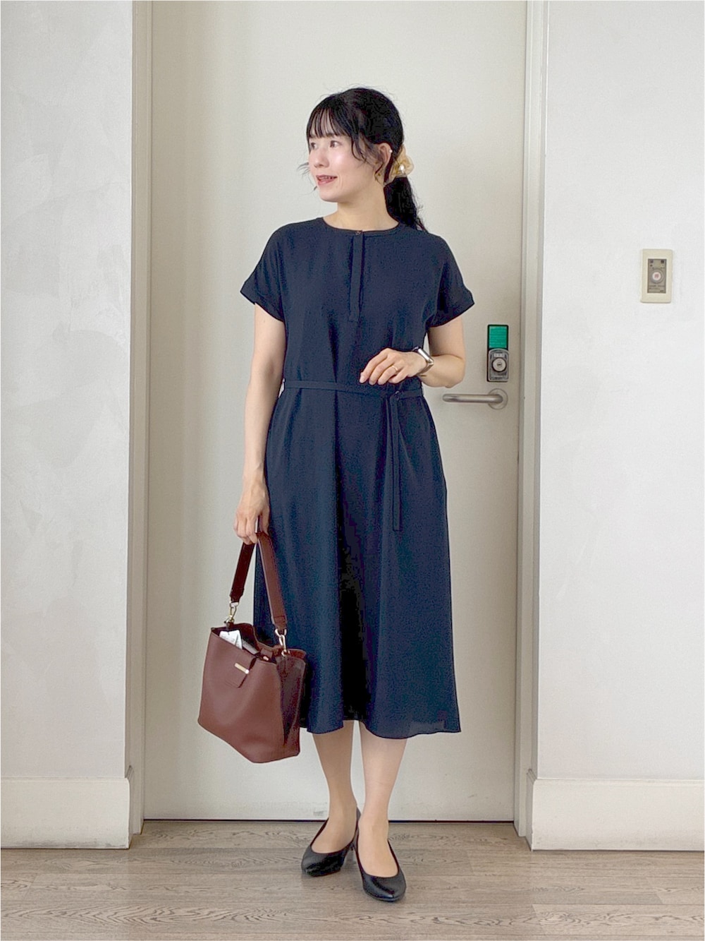 ブラック系のカーディガン/ボレロ、ブルー系のワンピース、ブラック系のトートバッグを着用したレディースの秋コーディネートの9枚目の写真