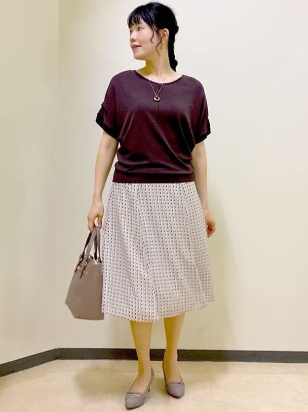ブラウン系のニット/セーター、ベージュ系のスカート、レッド系のTシャツ/カットソーを着用したレディースの夏コーディネートの6枚目の写真