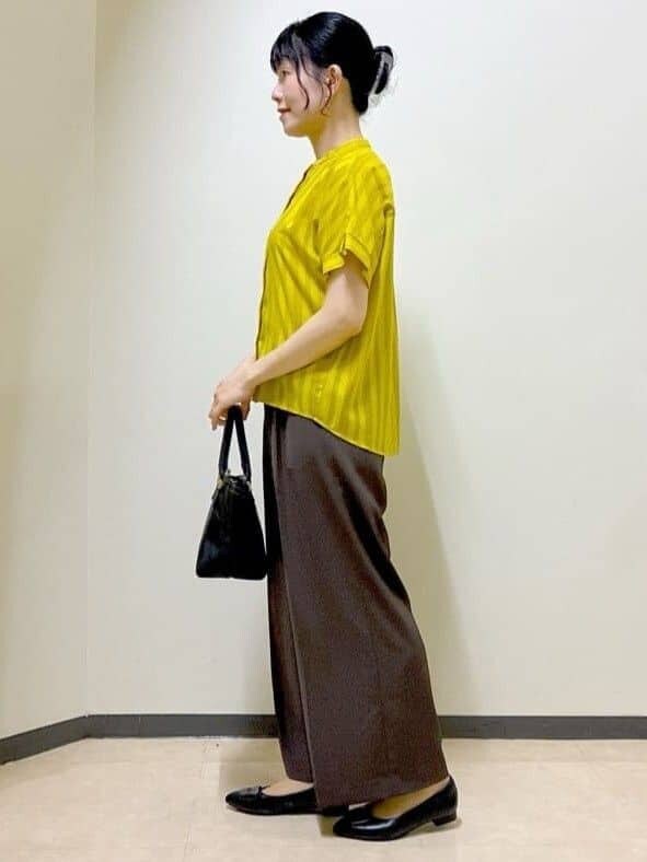 イエロー系のシャツ/ブラウス、ブラウン系のその他パンツ、ブラック系のトートバッグを着用したレディースの夏コーディネートの2枚目の写真