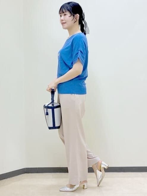 ベージュ系のその他パンツ、ブルー系のニット/セーター、ブルー系のショルダーバッグを着用したレディースの春コーディネートの2枚目の写真