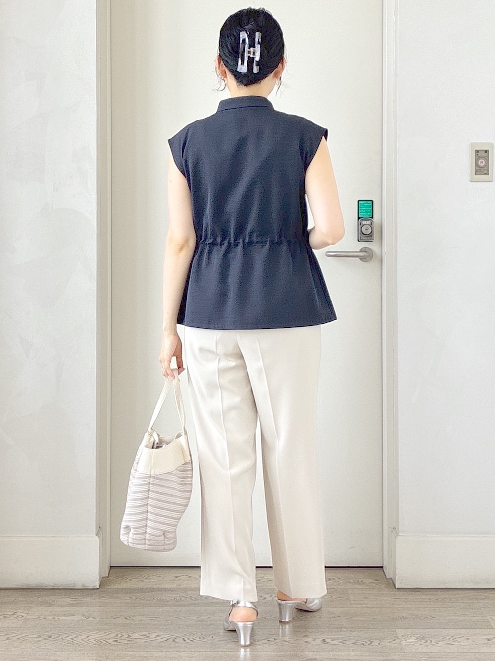 ブルー系のベスト、ベージュ系のその他パンツ、ベージュ系のトートバッグを着用したレディースの春コーディネートの3枚目の写真