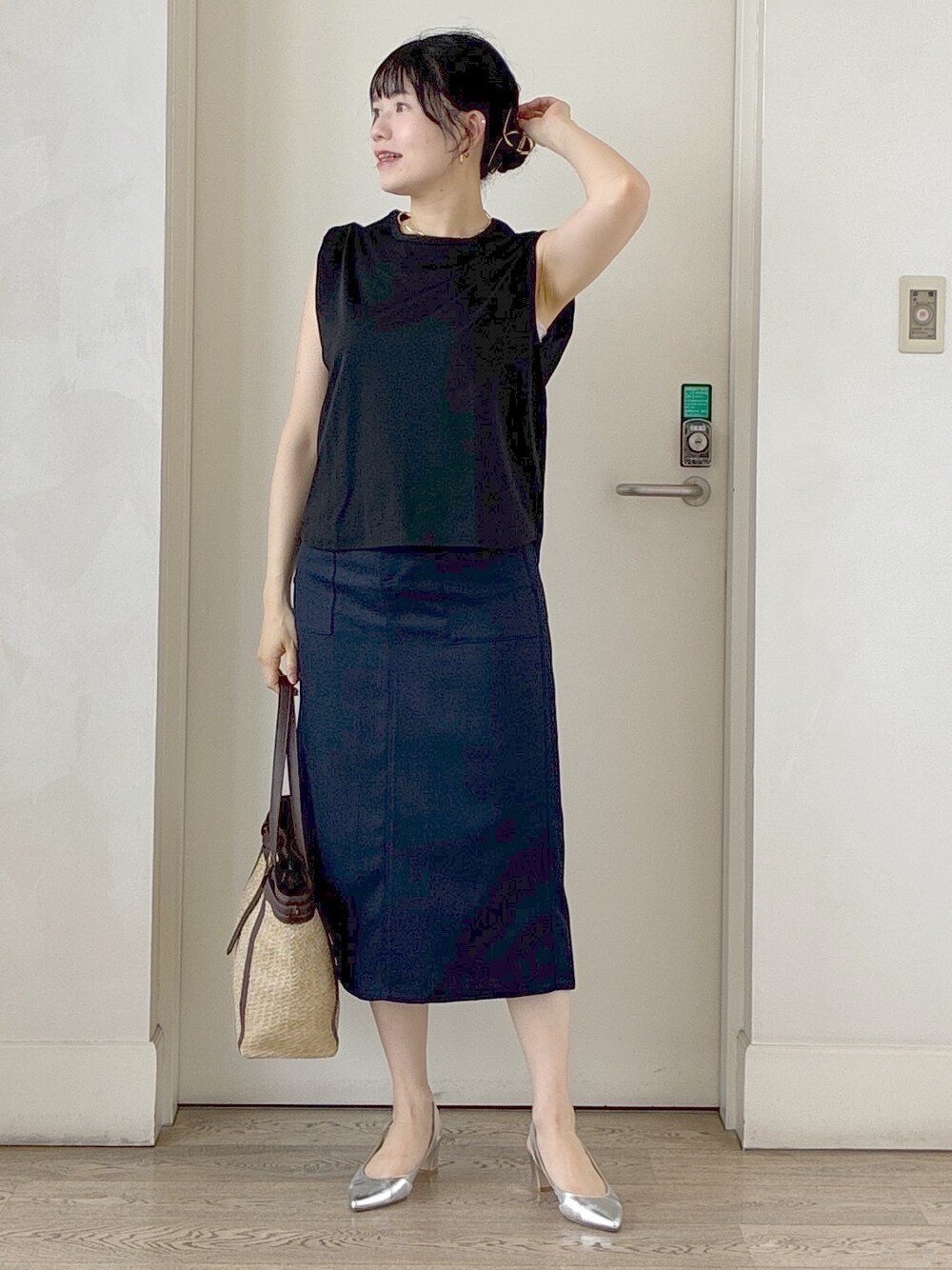 ブラック系のTシャツ/カットソー、ブルー系のスカート、イエロー系のトートバッグを着用したレディースの夏コーディネートの5枚目の写真