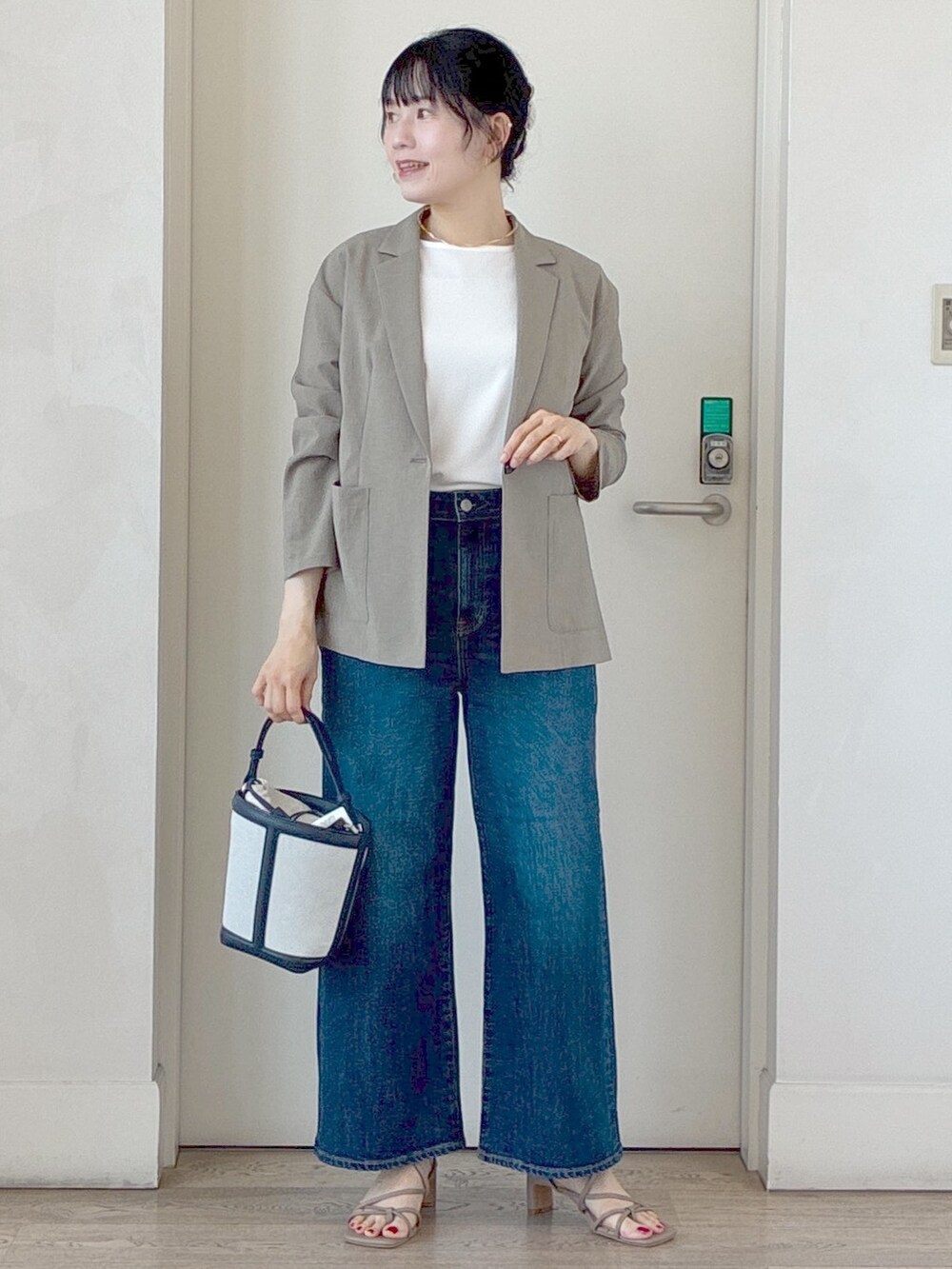 グリーン系のテーラードジャケット、ホワイト系のTシャツ/カットソー、ブルー系のデニムパンツを着用したレディースの夏コーディネートの5枚目の写真