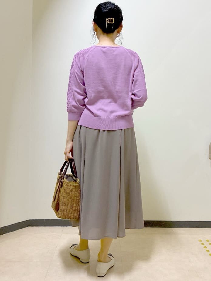 ピンク系のニット/セーター、ブルー系のデニムジャケット、ブラウン系のスカートを着用したレディースの春コーディネートの3枚目の写真