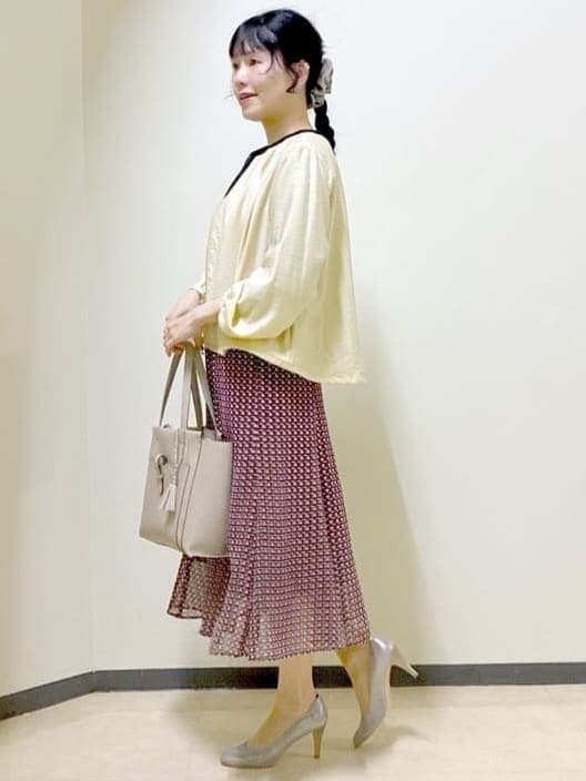 レッド系のスカート、ベージュ系のブルゾン、ベージュ系のトートバッグを着用したレディースの春コーディネートの2枚目の写真