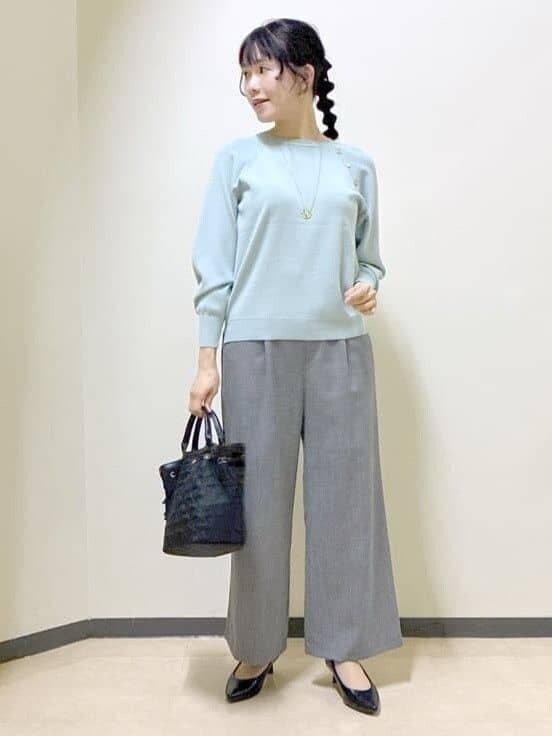 グリーン系のニット/セーター、グレー系のその他パンツ、ブラック系のトートバッグを着用したレディースの冬コーディネートの6枚目の写真
