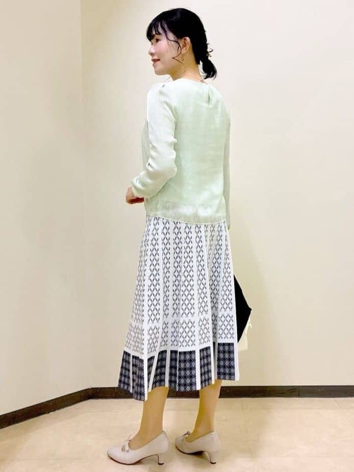 ブルー系のカーディガン/ボレロ、グリーン系のシャツ/ブラウス、ホワイト系のスカートを着用したレディースの春コーディネートの9枚目の写真