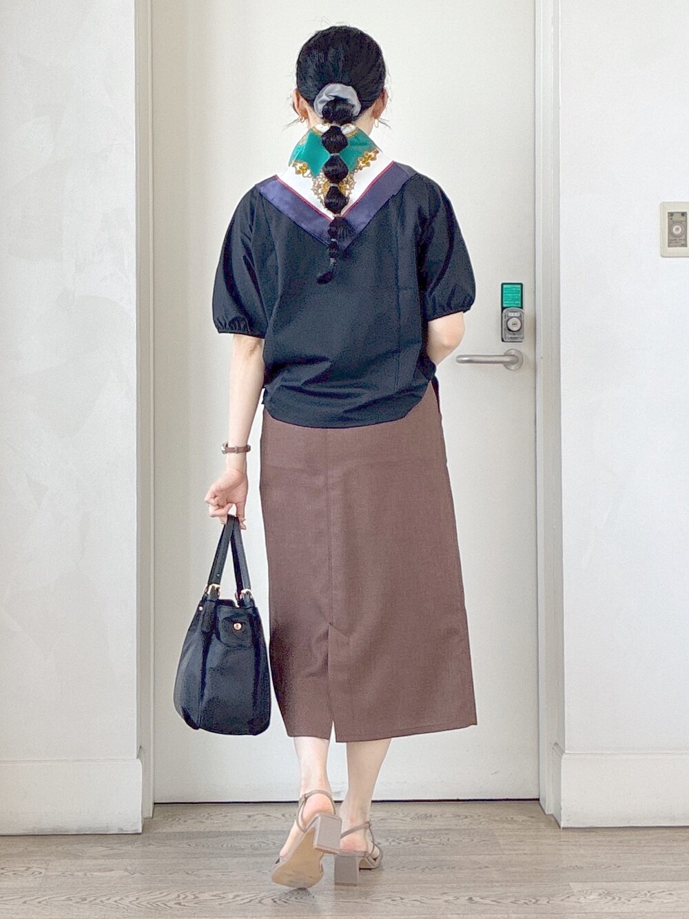ブラック系のTシャツ/カットソー、ブラウン系のスカート、ブラック系のトートバッグを着用したレディースの夏コーディネートの3枚目の写真