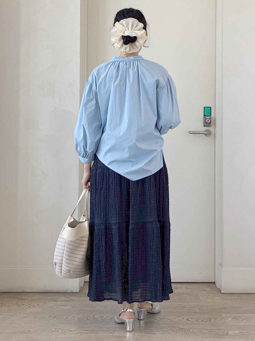 ブルー系のシャツ/ブラウス、ベージュ系のトートバッグ、ベージュ系のタンクトップを着用したレディースの春コーディネートの3枚目の写真