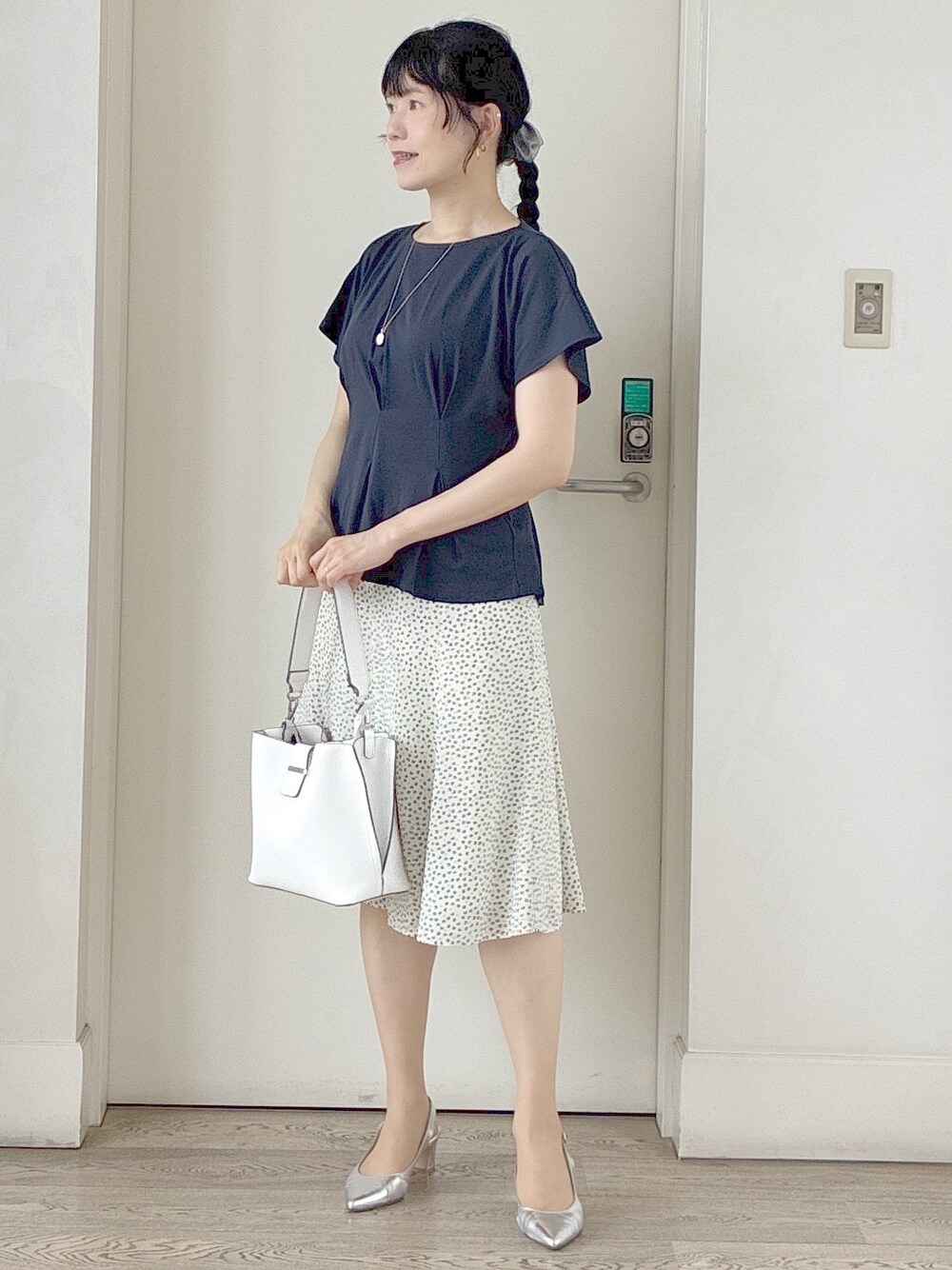 ブルー系のTシャツ/カットソー、ベージュ系のスカート、ホワイト系のトートバッグを着用したレディースの春コーディネートの7枚目の写真