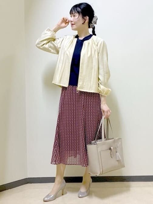 ベージュ系のブルゾン、ブルー系のニット/セーター、レッド系のスカートを着用したレディースの春コーディネートの5枚目の写真