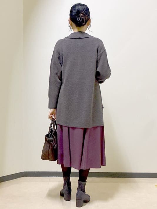 ブラウン系のカーディガン/ボレロ、ブラック系のニット/セーター、レッド系のスカートを着用したレディースの冬コーディネートの3枚目の写真
