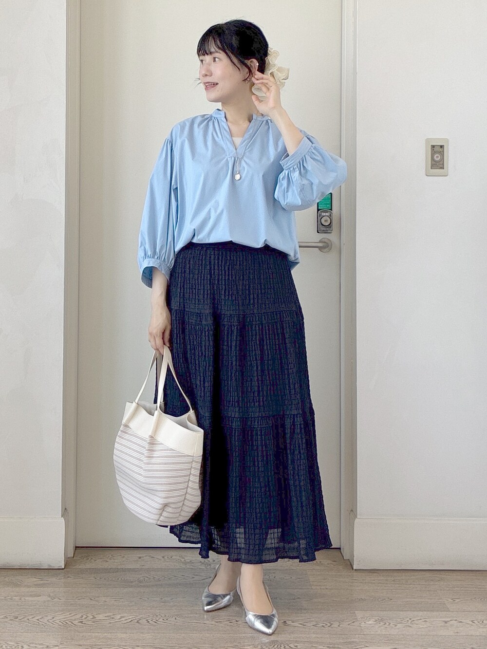 ブルー系のシャツ/ブラウス、ベージュ系のトートバッグ、ベージュ系のタンクトップを着用したレディースの春コーディネートの5枚目の写真