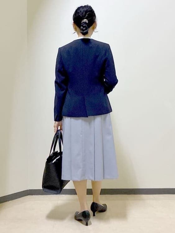ブルー系のノーカラージャケット、ホワイト系のシャツ/ブラウス、ブラック系のトートバッグを着用したレディースの春コーディネートの3枚目の写真