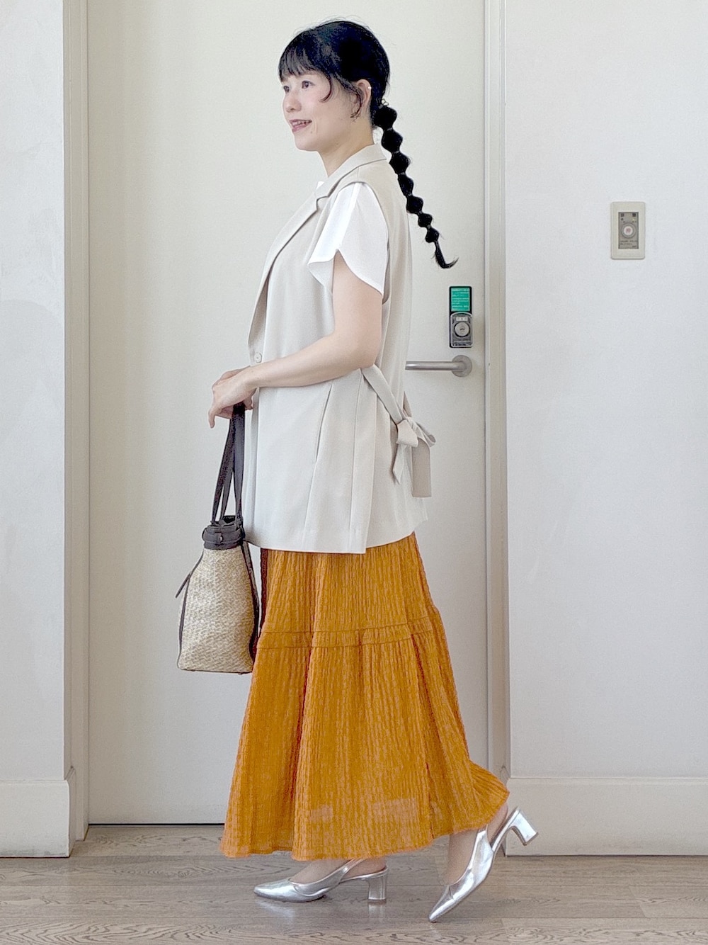 ホワイト系のTシャツ/カットソー、オレンジ系のスカート、イエロー系のトートバッグを着用したレディースの夏コーディネートの2枚目の写真