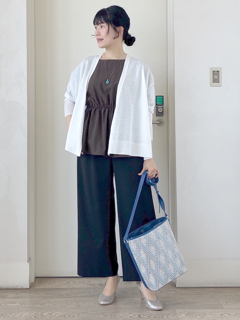ブラック系のその他パンツ、ブルー系のショルダーバッグ、ホワイト系のカーディガン/ボレロを着用したレディースの春コーディネートの9枚目の写真