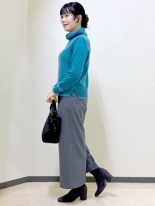 ブルー系のニット/セーター、グレー系のその他パンツ、ブラック系のダウンジャケット/コートを着用したレディースの冬コーディネートの2枚目の写真