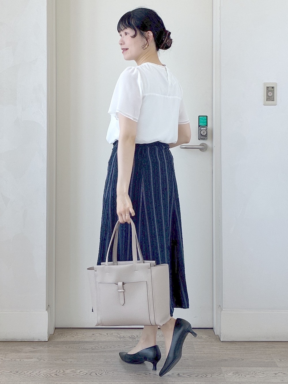 イエロー系のカーディガン/ボレロ、ホワイト系のシャツ/ブラウス、ブルー系のスカートを着用したレディースの春コーディネートの10枚目の写真