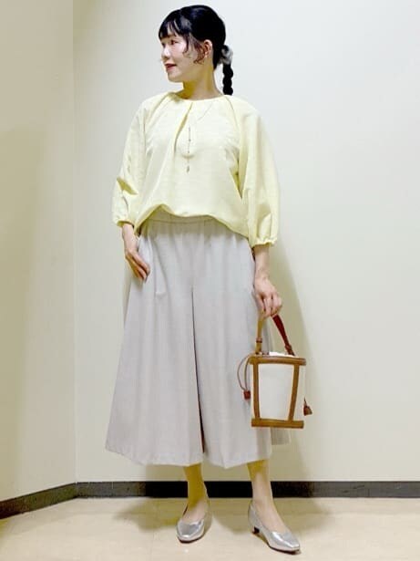 イエロー系のシャツ/ブラウス、シルバー系のパンプス、イエロー系のショルダーバッグを着用したレディースの春コーディネートの6枚目の写真