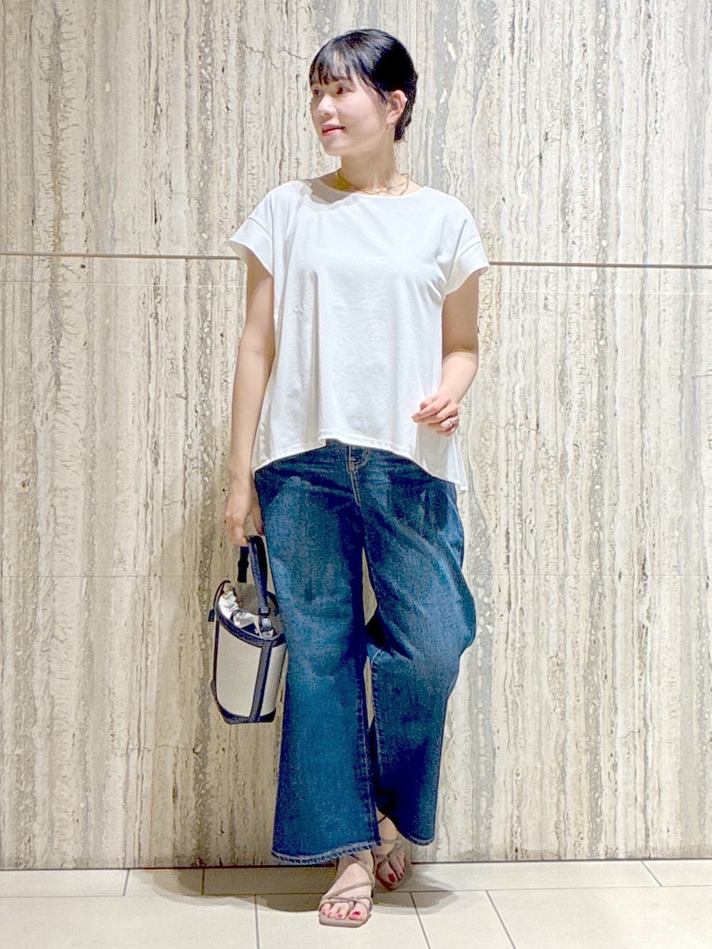 ホワイト系のチュニック、ブルー系のデニムパンツ、オレンジ系のカーディガン/ボレロを着用したレディースの夏コーディネートの6枚目の写真