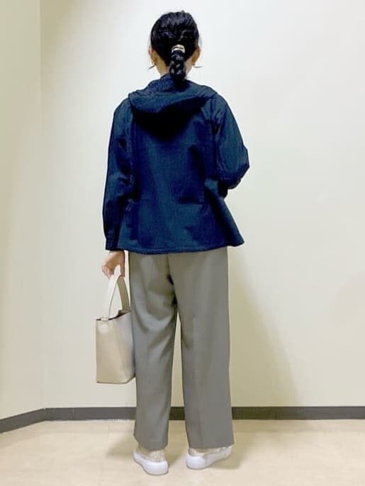 ブルー系のブルゾン、オレンジ系のニット/セーター、ベージュ系のその他パンツを着用したレディースの春コーディネートの3枚目の写真