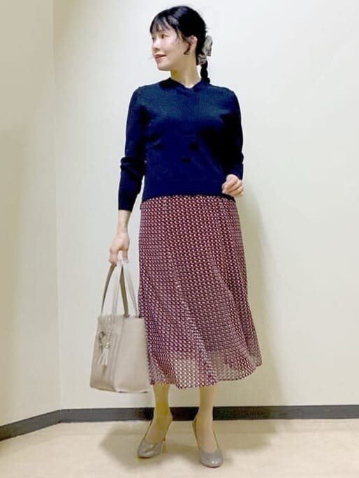 ベージュ系のブルゾン、ブルー系のニット/セーター、レッド系のスカートを着用したレディースの春コーディネートの9枚目の写真