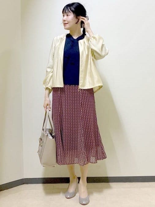 ベージュ系のブルゾン、ブルー系のニット/セーター、レッド系のスカートを着用したレディースの春コーディネートの7枚目の写真