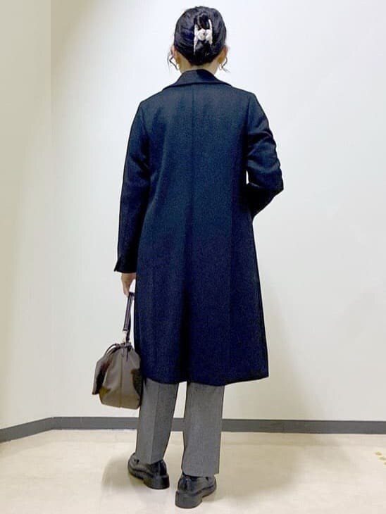 ブラック系のチェスターコート、レッド系のニット/セーター、ホワイト系のTシャツ/カットソーを着用したレディースの冬コーディネートの3枚目の写真