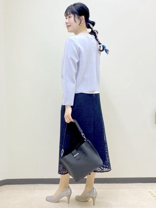 パープル系のカーディガン/ボレロ、ホワイト系のニット/セーター、ブルー系のスカートを着用したレディースの春コーディネートの4枚目の写真