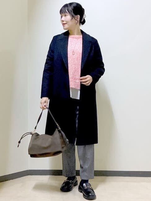 ブラック系のチェスターコート、レッド系のニット/セーター、ホワイト系のTシャツ/カットソーを着用したレディースの冬コーディネートの7枚目の写真