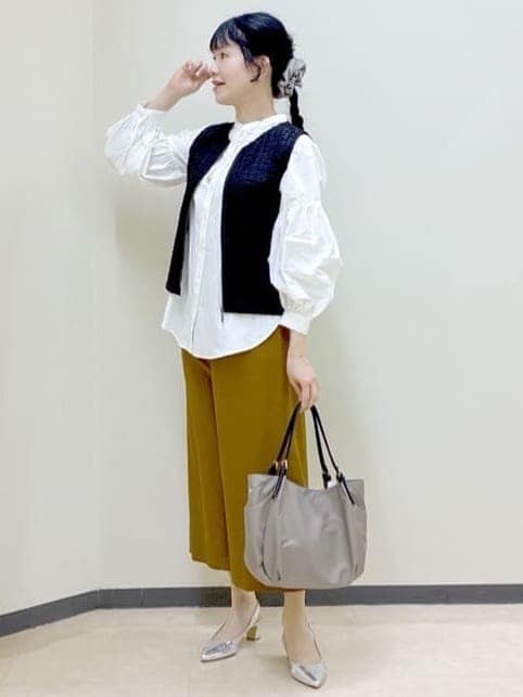 イエロー系のその他パンツ、ブラック系のベスト、ブラウン系のショルダーバッグを着用したレディースの春コーディネートの7枚目の写真