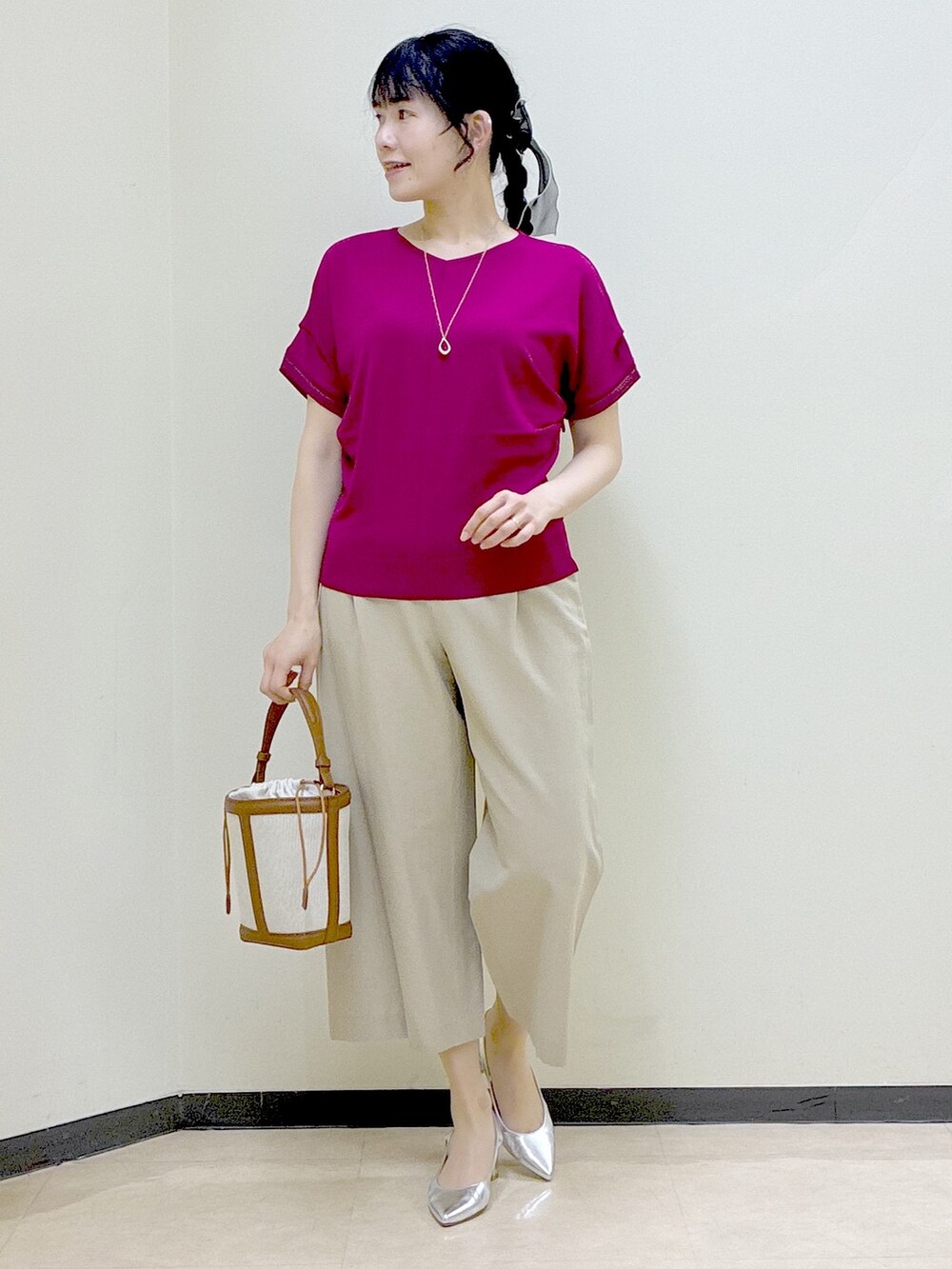 ピンク系のニット/セーター、ベージュ系のその他パンツ、イエロー系のショルダーバッグを着用したレディースの春コーディネートの5枚目の写真