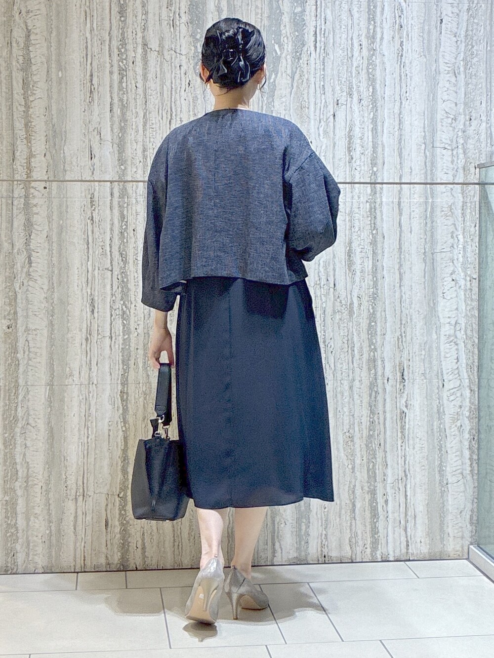 ブルー系のノーカラージャケット、ブルー系のワンピース、ブラック系のトートバッグを着用したレディースの夏コーディネートの3枚目の写真